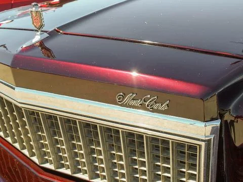 Front grill and headlight of a sparkling dark red Chevrolet Monte Carlo show Stock Photos