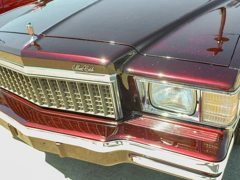 Front grill and headlight of a sparkling dark red Chevrolet Monte Carlo show Foto stock