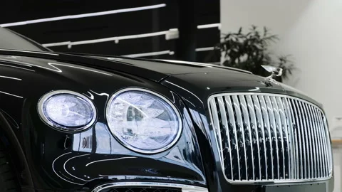 Front headlight and chrome radiator grille of the new black Bentley Flying Spur  Stock Footage 147537608