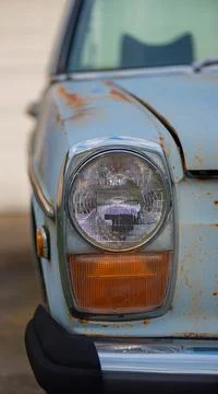 Front Headlight view of a classic blue car Stock Photos