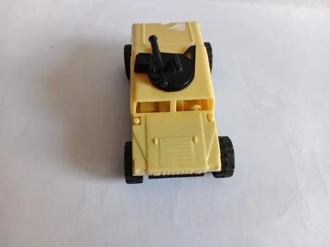 Front High Angle View of a Beige Plastic Toy Military Vehicle with Gun Turret 库存照片