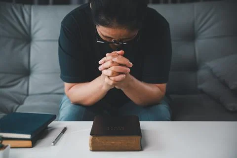 Front high-angle view of a middle-aged Christian woman praying with clasped.. Stock Photos