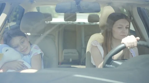 Front high angle view of two siblings sitting inside the car driving in the city Stock Footage 112749037