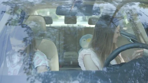 Front high angle view young mother and her daughter sitting inside the car Stock Footage 112749220