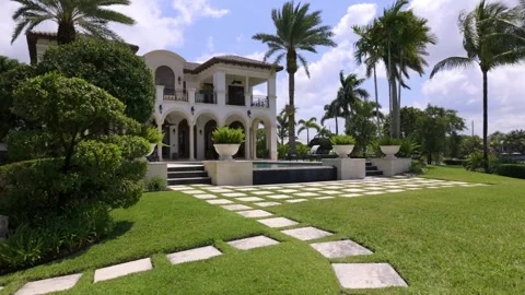 Front of house with stone path, blue sky, outdoor furniture and trees. Stock Footage 239178854