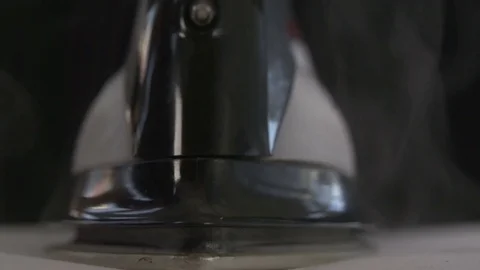 The front of an iron with steam clouds as it rests on clothing Stock Footage 71338783