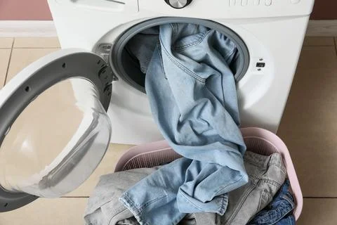 Front load washing machine with denim clothes Stock Photos