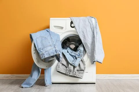 Front load washing machine with denim clothes Stock Photos