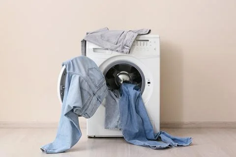 Front load washing machine with denim clothes Stock Photos