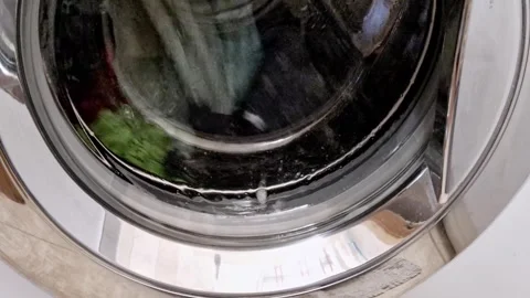 Front load washing machine drum with spinning clothes Video stock 319013939