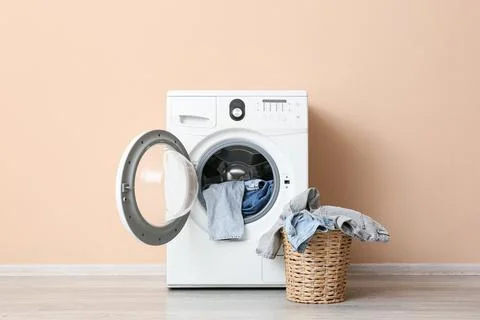 Front load washing machine with laundry basket and clothes Stock Photos