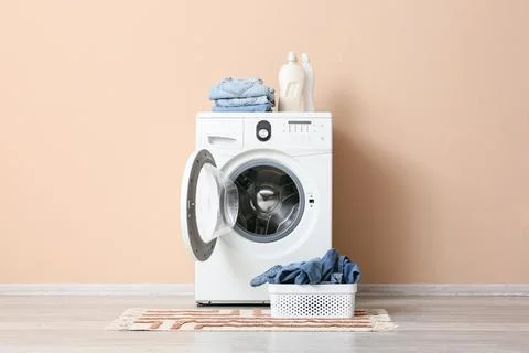 Front load washing machine with laundry and detergent bottles Stock Photos