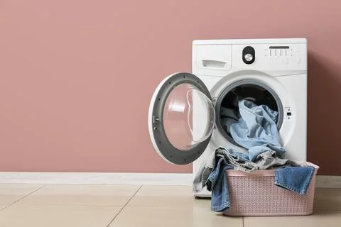 Front load washing machine with laundry basket and clothes Stock Photos