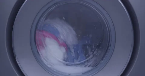 Front Load Washing Machine Spinning with Clothes inside with a lot of foam Stock Footage 172379557