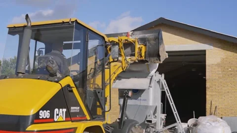 Front Loader Dumping Construction Material into Mixer Stock Footage 332976070