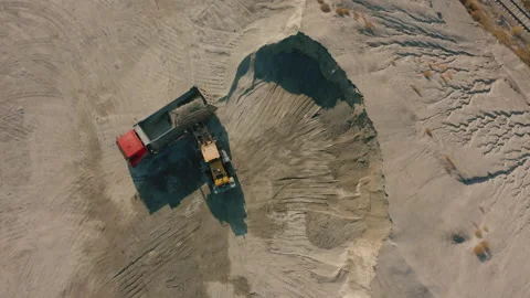 Front loader loading crushed stone into dump truck in quarry, aerial top down Stock Footage 165388086