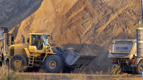 Front Loader Loading Sand on Dumper Trucks on Construction Site Video stock 139896210