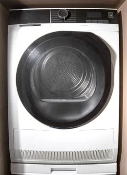 Front loading dryer machine installed in cabinet niche. Household appliance.. Fotos de archivo