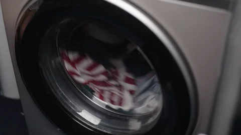 Front-loading washing machine drum spinning at high speed, cleaning clothes Stock Footage 320673898