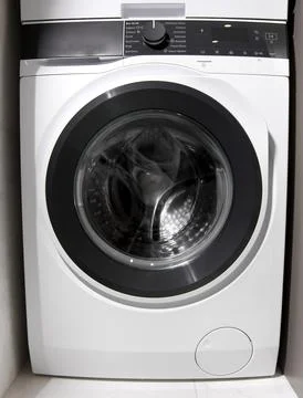 Front loading washing machine installed in cabinet niche. Household appliance Foto stock