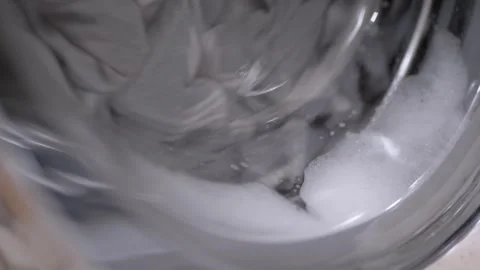 Front Loading Washing Machine Rotating Wet Laundry in Soapy Water Stock-Footage 332663220