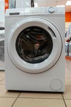 Front-loading washing machine showcased in a retail appliance store Stock Photos