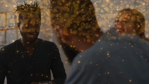 Front man turning, starting joke, two friends laughing at table, gold bokeh over Stockbeeldmateriaal 333575059