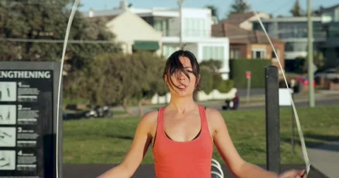 Front on medium shot of Eurasian female skipping in the park Stock Footage 138253586