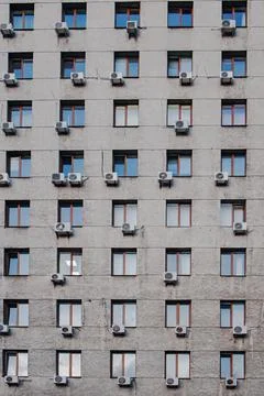 Front of an old grey office building with a lot s of air conditions Stock Photos