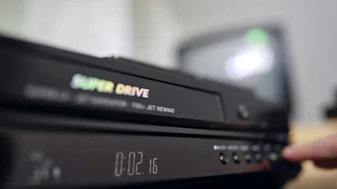 Front panel of the old VHS player. Close up. Hand presses the button on Stock Footage 320797513