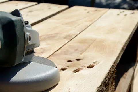 Front part of angle grinder with abrasive disc on planks after work. Stock-Fotos