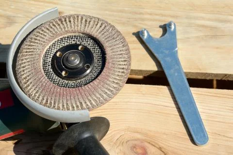 Front part of angle grinder with abrasive disc and spanner after work. Stock Photos