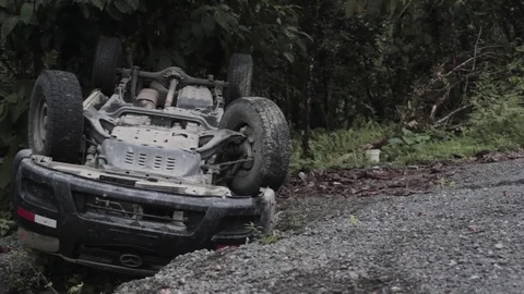 Front part of a flipped car on road side after an accident Stock Footage