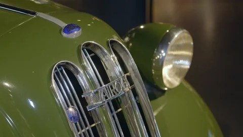 Front radiator grill and headlamp of classic, green, luxury car Ford Stock Footage 124696053