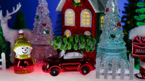 In front of a red house, there is a snowman and a red car Stock Footage 322510685