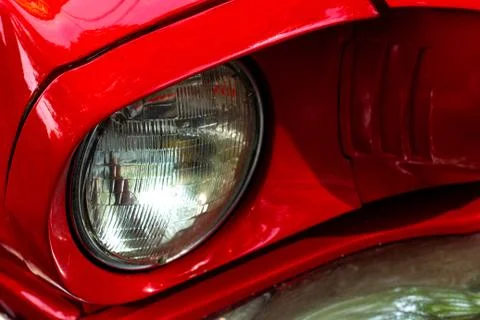 Front round headlight of a red retro car. Detail of an old vintage car. Modern Stock Photos