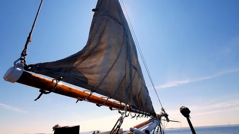 The front sail of an old ship being hoisted to set sail on a beautiful Stock Footage 127953679