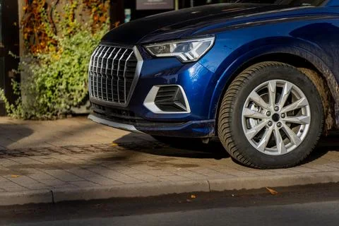 Front section of modern blue SUV parked on city street showing detailed front Foto stock
