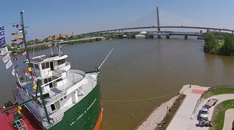 Front of Ship with flags, River and Bridge - Aerial Video Video stock 40331664