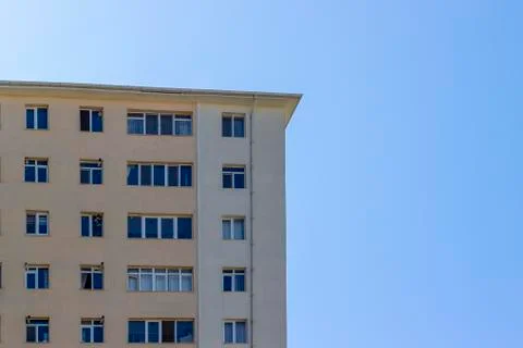 Front shoot of concrete structured mass housing clear yellow colored facade Stock Photos