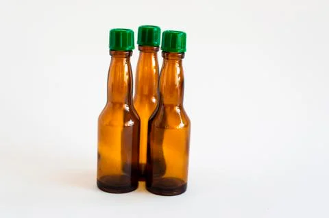 Front shoot of three angled positioned small alcohol bottles brown colored Stock Photos