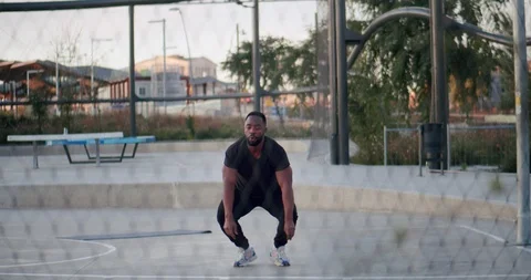 Front shoot through metal net of powerful fitness man doing intense exercises Stock Footage 123664932