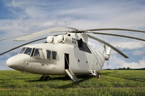 Front-side view of big white cargo helicopter with open door and ladder parke Stock Photos
