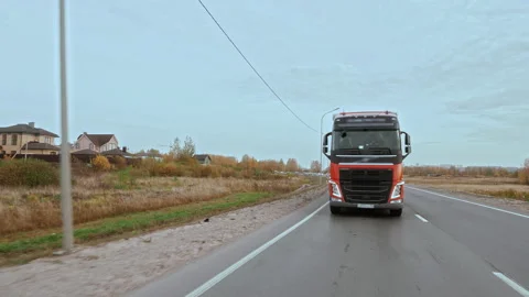 Front Side view of semi truck with cargo trailer driving alone on multilane road Stock Footage 176409157