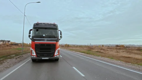 Front Side view of truck with cargo trailer driving alone on multilane road Stock Footage 203745547