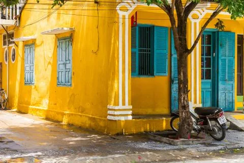 Front side view yellow building motorbike shutters Foto stock