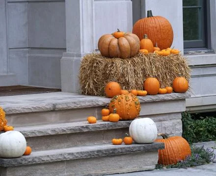 Front steps of home with different sized pumpkins and straw as Halloween dec Stock Photos