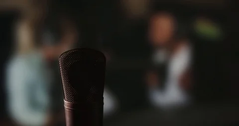 In front of a studio microphone with the producers in the window in the back Stock Footage 99916687