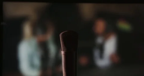 In front of a studio microphone with the producers in the window in the back Stock Footage 99916701