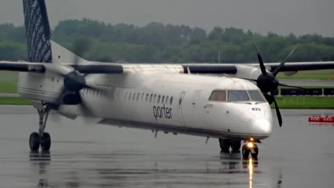 Front three quarter view of Porter Airlines turboprop airplane taxiing Stock Footage 341836638